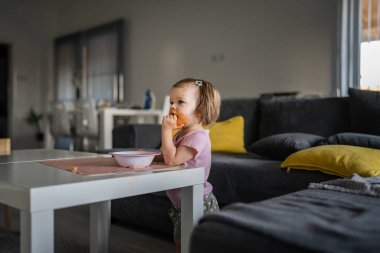 Küçük beyaz bir kız çocuğu. Evde tek başına yemek yerken televizyonun yüzünü kirletmesini izliyor. Kirli sos çocukluğu, kalkınma kavramının fotokopisini çekiyor.