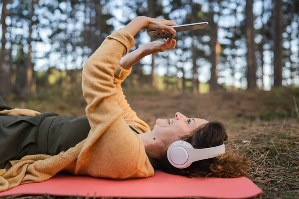 Çevrimiçi Meditasyon Için Dijital Tablet Kulaklıklarla Parkta Ormanda Tek Başına — Stok fotoğraf