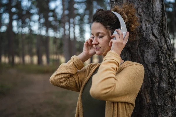 Genç Beyaz Bir Kadın Parkta Ormanda Yalnız Başına Oturuyor Kulaklıkları — Stok fotoğraf