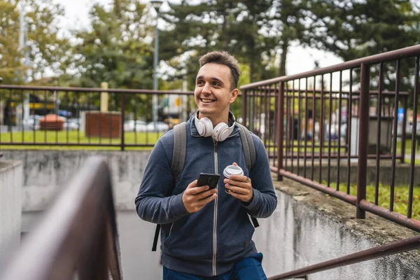 Genç Yetişkin Bir Erkek Elinde Kahve Cep Telefonuyla Merdivenlerden Çıkıyor — Stok fotoğraf