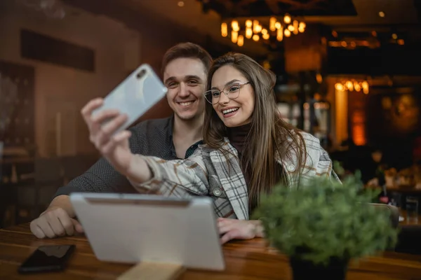 一对年轻的高加索夫妇男女有别的男女朋友或男友和女友在咖啡馆边拍照或打一个视频电话复制空间的乐趣和浪漫 — 图库照片