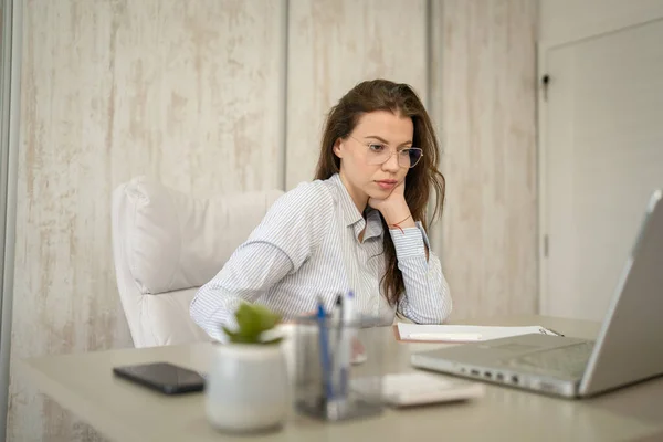 stock image One woman female caucasian entrepreneur businesswoman or secretary sitting at her office at desk work on laptop computer wear shirt copy space