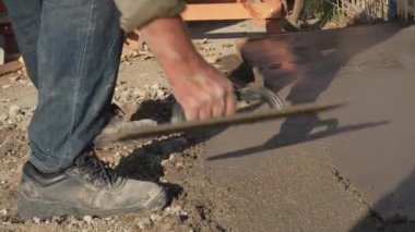 Alçı işçiliği İnşaat işçisi, betonun tepesini betonla kaplayarak istenen pürüzsüzlüğe ulaşmak için kaldırım döşemesi kullanıyor.