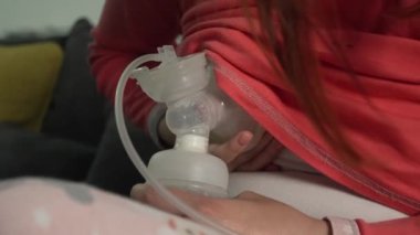Bilinmeyen beyaz kadının karnını kapatın ve bebeği için bebek şişesi ve göğüs pompası kullanın. Geceleri süt pompalayın. Ebeveynlik ve annelik kavramı.