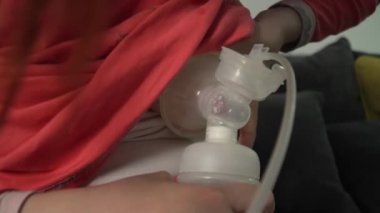 Bilinmeyen beyaz kadının karnını kapatın ve bebeği için bebek şişesi ve göğüs pompası kullanın. Geceleri süt pompalayın. Ebeveynlik ve annelik kavramı.
