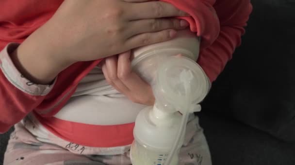 夜に自宅で赤ちゃんや授乳のために赤ちゃんのボトルと胸ポンプミルクを保持し 使用して未知の原因アジアの女性の中央部に閉じます 親と母親の概念 — ストック動画