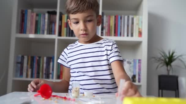 Ein Vorschulkind Das Hause Spielt Sitzt Tisch Mit Naturwissenschaftlichen Experimentierspielzeugen — Stockvideo