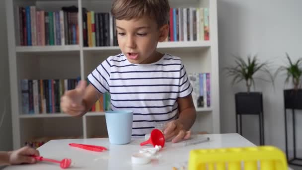 Anaokulundan Bir Çocuk Evde Oturmuş Bilim Deneyi Oyuncaklarıyla Oynuyor Kameraya — Stok video