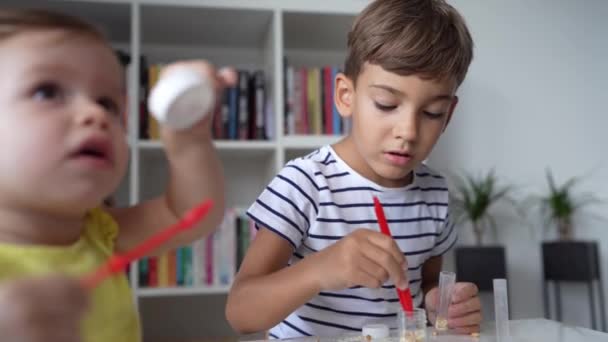 Jeden Předškolní Chlapec Hraje Doma Vědeckými Experimenty Zatímco Jeho Malá — Stock video
