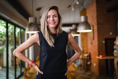 One woman middle age caucasian female standing at home in dining room or restaurant happy smile confident wear black waist up copy space front view portrait