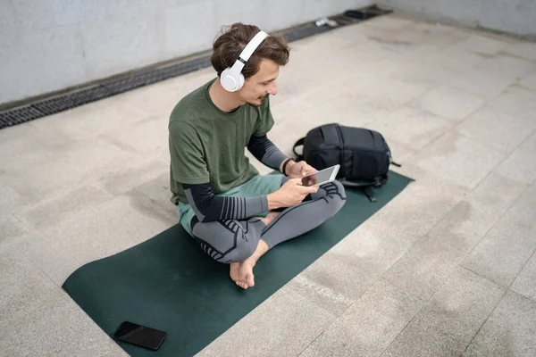 Yetişkin Bir Erkek Yoga Meditasyona Hazırlanırken Kulaklıklarla Dışarıda Otururken Dijital — Stok fotoğraf
