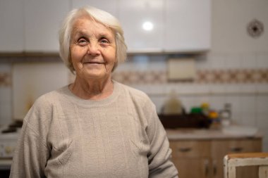 Yaşlı, yaşlı bir kadın Kafkas emeklisi ev yapımı portre üzerinde duruyor ve kamera bunaması Alzheimer hastalığının konseptine bakıyor.