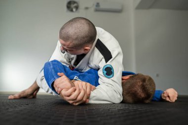 Brezilya jiu jitsu americana 'yı eğiten iki sporcu akademide BJJ' nin kollarını kimono giyerek kilitliyorlar.