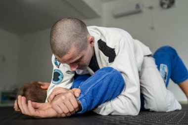 Brezilya jiu jitsu americana 'yı eğiten iki sporcu akademide BJJ' nin kollarını kimono giyerek kilitliyorlar.