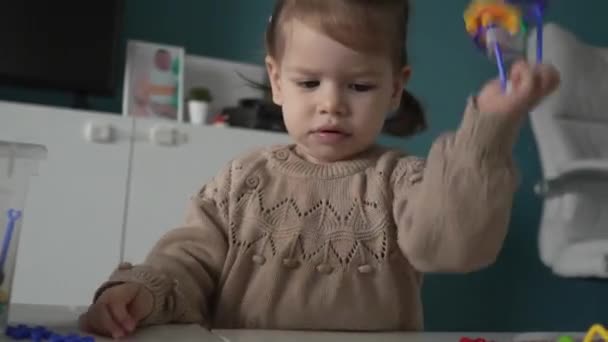 一个带着奶嘴奶嘴的幼儿小孩独自在家里的桌子边玩耍 他从小就是一个概念复制的空间 — 图库视频影像