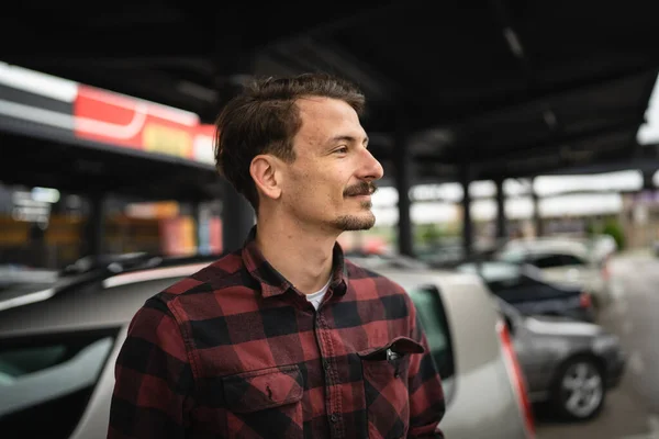 駐車場に車で立っている一人の男大人の白人男性側を見ながら幸せな笑顔自信を持って本当の人々の居心地の良い空間 — ストック写真