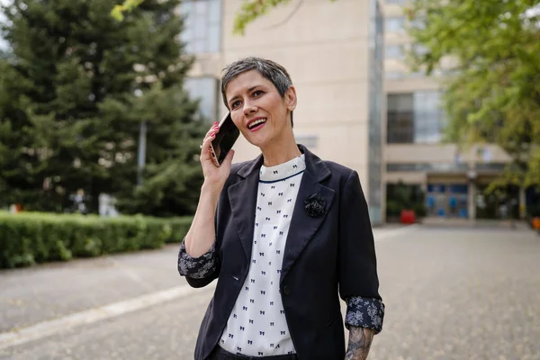 1人の女性シニア成熟した白人女性が屋外に立っている日に携帯電話を使用して通話をするだけで本当の人々のビジネスコミュニケーションコピースペース — ストック写真
