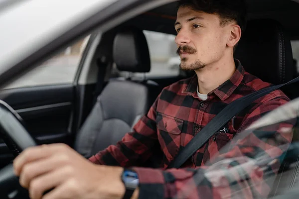 one man caucasian male with brown hair and mustaches sitting in a car adult driver wear shirt while driving automobile travel transport concept real people copy space