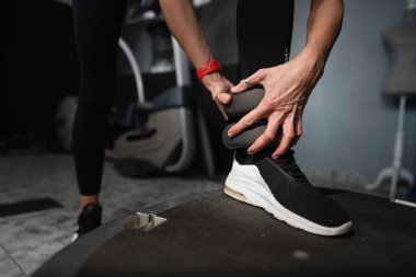 Bilinmeyen beyaz kadının ayak ucuna yaklaş. Ayak bileğine ağırlık koy. Kopya alanı eğitimi için hazırlan.