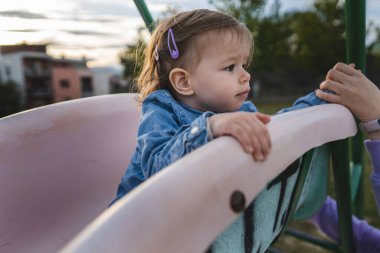 Küçük beyaz bir kız. 18 aylık beyaz çocuk. Gündüz kaydırağında eğleniyor ve büyüyen konsept fotokopi alanı.