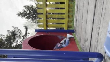 Bir kız çocuğu iki yaşında parkta oynuyor. Sadece kış ya da sonbahar günü oyun parkında kaydırağa tırmanıyor. UGC kullanıcısı içeriği dikey video üretiyor.