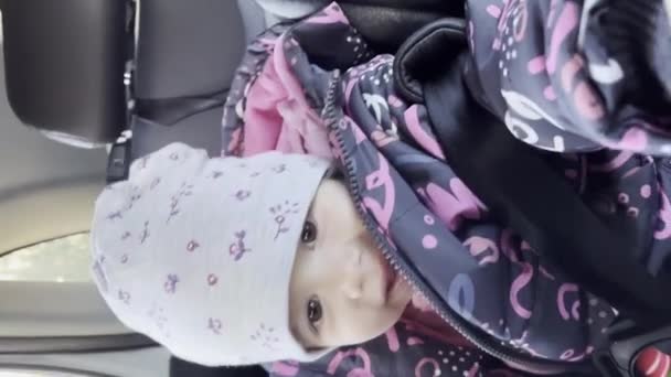 Bir Küçük Beyaz Çocuk Emniyet Arabasının Koltuğunda Oturuyor Kışın Ceketini — Stok video