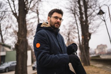 one caucasian man standing alone in autumn day holding a business bag laptop real people young businessman going to work