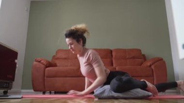 Adult caucasian woman practice restorative yoga on the floor at home use pillows for support and practice self care meditation and relaxation on the floor real people well-being concept