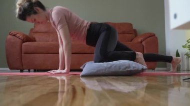 Adult caucasian woman practice restorative yoga on the floor at home use pillows for support and practice self care meditation and relaxation on the floor real people well-being concept