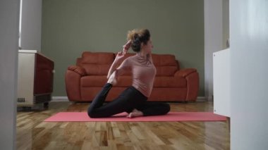 one woman caucasian female doing yoga pose stretching on the mat on the floor at home daily routine self care concept relaxation practice sequence well-being 