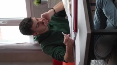 one young man caucasian teenager student learning study reading book while sitting at home prepare exam or work on project real people education concept