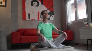 senior woman doing guided meditation yoga self care practice at home
