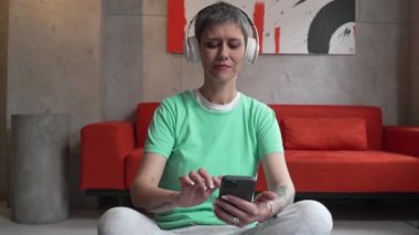 senior woman doing guided meditation yoga self care practice at home