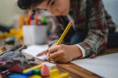 Small caucasian boy play at home draw on the floor childhood development growing up concept copy space domestic life focus on hand