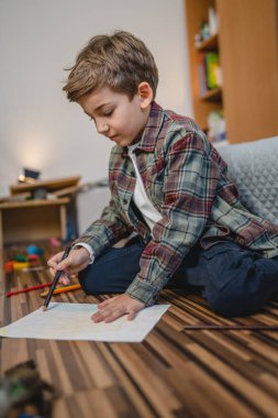 one small caucasian boy Gradeschooler child draw with crayon at home