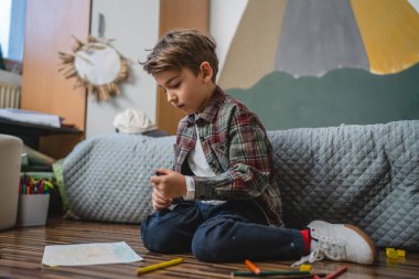 one small caucasian boy Gradeschooler child draw with crayon at home