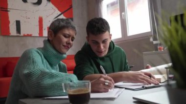 One student teenage caucasian man study learn with help of his tutor professor or mother senior woman at home having private lesson to prepare for exam education concept real people