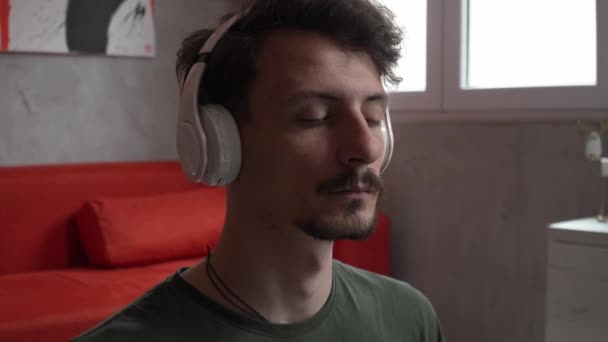 Ένας Άνδρας Ενήλικας Καυκάσιος Άνδρας Κάθεται Στο Σπίτι Χρήση Ακουστικών — Αρχείο Βίντεο