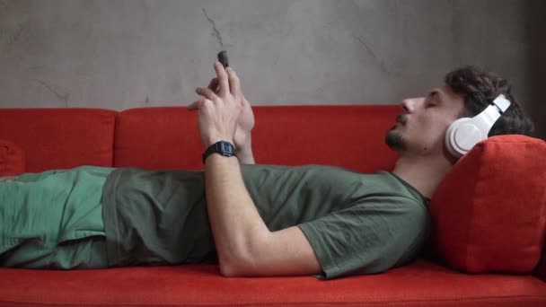 Egy Férfi Felnőtt Kaukázusi Férfi Otthon Használja Fejhallgató Okostelefon Játszani — Stock videók