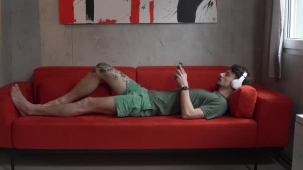 One Man Adult Caucasian Male Sit Home Use Headphones Smartphone — Videoclip de stoc