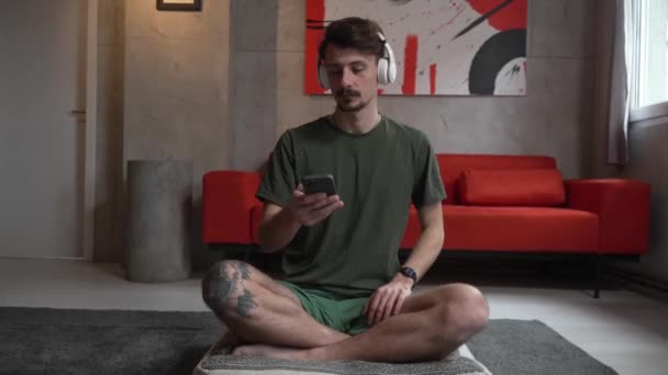 One Adult Caucasian Man Sit Home Headphones Head Use Mobile — Stok Video