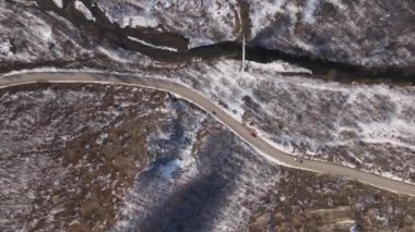 Car drive in snow winter day on the road in mountain range aerial view