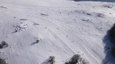 Kayakçı kış günü tepeden aşağı kayak pistinde eski Stara Dağı planinasında Babin Zub tatil beldesi insansız hava aracı görüntüsünde.