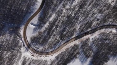 Car drive in snow winter day on the road in mountain range aerial view old mountain stara planina babin zub top down