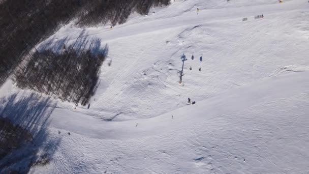 带贡多拉型缆车滑雪者在冰雪覆盖的滑雪场斜坡上滑行滑雪场景观雪地滑雪场空中无人飞机俯瞰旧山巴尔干 — 图库视频影像