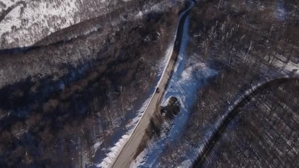 山岳地帯の道路上の雪の冬の日の車のドライブ空中ドローンビュー古い山の星のプラニーナバビンズブ — ストック動画