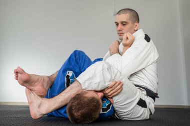 Brezilya jiu jitsu bjj eğitimi ya da iki sporcuyu serbest bırakmak tatami minderlerinde dövüş sanatları tekniği. Kimono gi siyah kuşak eğitmeni.