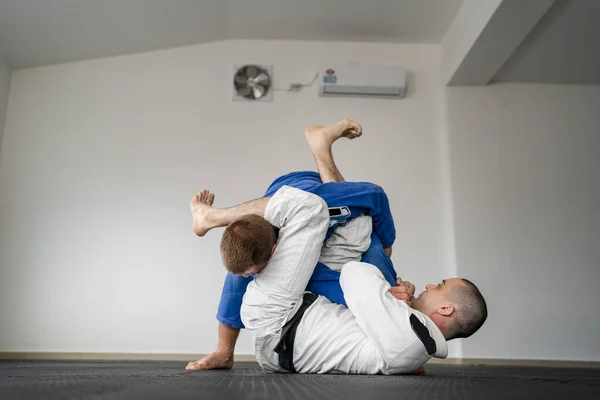 Brezilya jiu jitsu bjj eğitimi ya da iki sporcuyu serbest bırakmak tatami minderlerinde dövüş sanatları tekniği. Kimono gi siyah kuşak eğitmeni.
