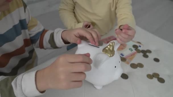 Close Hands Unknown Children Putting Money Coins Piggy Bank Finance — Vídeo de Stock