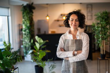 One mature woman caucasian female gardener or florist take care and cultivate domestic flowers plants at home gardening concept copy space